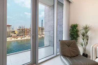 a living room with a large window and a chair at New Luxury Canalfront 2 Bedroom Apartment with Burj Views in Dubai