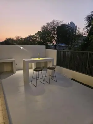 a white table and two stools on a patio at Modern Townhouse in Tilal Al Ghaf I Aura Gardens in Dubai