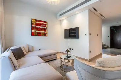 a living room with two couches and a tv at Modern Townhouse in Tilal Al Ghaf I Aura Gardens in Dubai