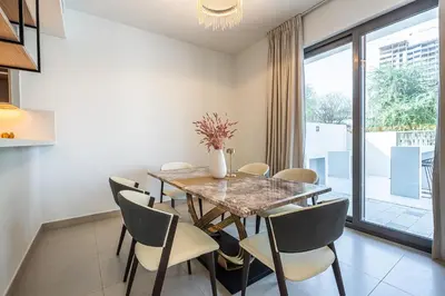 a dining room with a table and chairs at Modern Townhouse in Tilal Al Ghaf I Aura Gardens in Dubai