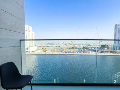 a chair sitting in front of a window with a view of the water at Luxury Studio Business Bay Near Dubai Mall in Dubai