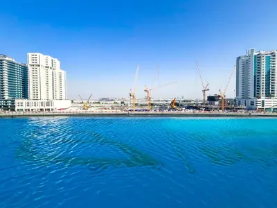 a large body of blue water with buildings and cranes at Luxury Studio Business Bay Near Dubai Mall in Dubai
