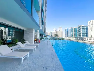 a swimming pool in a building with white lounge chairs at Luxury Studio Business Bay Near Dubai Mall in Dubai
