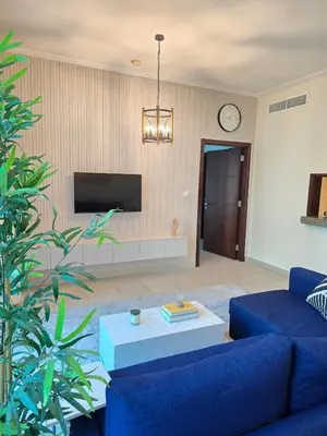 a living room with a blue couch and a tv at 1 BR Apartment in Dubai Marina - Paloma Tower - Sea View - 3 Mins away from Tram & Beach in Dubai