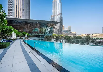 a large swimming pool in a city with tall buildings at Luxury Grande 48 with Burj Khalifa & Fountain Views in Dubai