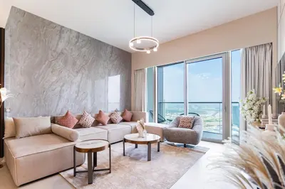 a living room with a couch and tables and windows at Luxury Grande 48 with Burj Khalifa & Fountain Views in Dubai