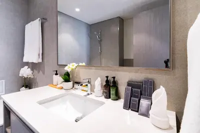 a bathroom with a white sink and a mirror at Luxury Grande 48 with Burj Khalifa & Fountain Views in Dubai