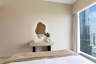 a bedroom with a bed and a mirror at Luxury Grande 48 with Burj Khalifa & Fountain Views in Dubai