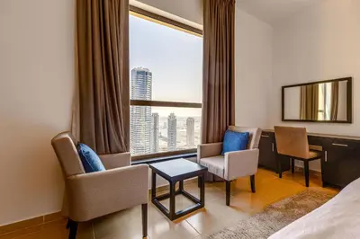 a hotel room with a bed and a desk and chairs at Modern 2 BDR Apartment with Sea View Shams 1 JBR in Dubai