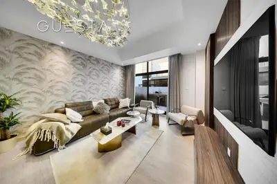 a living room with a couch and a chandelier at Senses at the Fields - Villa with a Private Pool in Dubai