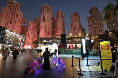 a group of people walking in a city at night at Stylish JBR Studio Beach View EB in Dubai