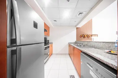 a kitchen with a stainless steel refrigerator at Surrounded by Nature Near Internet & Media City in Dubai