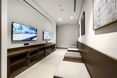 a waiting room with three benches and a flat screen tv at Vogue Downtown Grande Signature Residences, near Dubai Mall and Burj Khalifa, Two-Bedroom Apartment with Large Balcony, Infinity Pool with Burj Khalifa View, Access to all Amenities in Dubai
