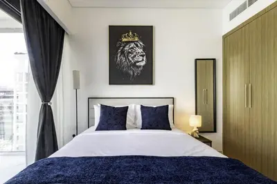a bedroom with a king sized bed with a crown on it at Azizi Riviera 63 in Dubai