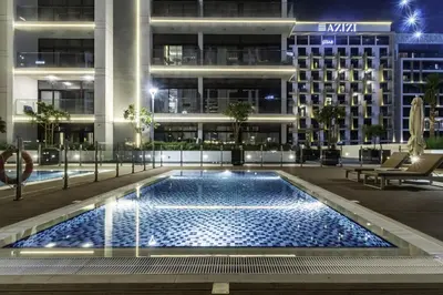 a swimming pool in front of a building at night at Azizi Riviera 63 in Dubai