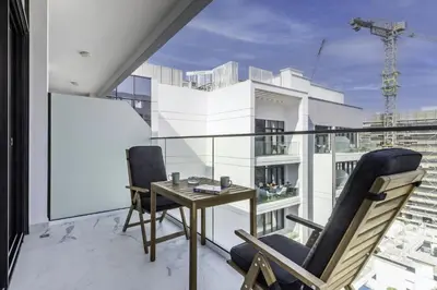 a balcony with a table and chairs on a building at Azizi Riviera 63 in Dubai