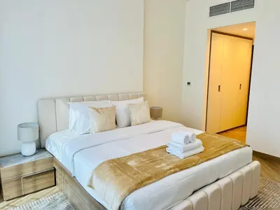 a bedroom with a large white bed with towels on it at Skyline 22 1 Residence in Dubai
