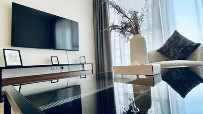a living room with a tv and a glass table at Skyline 22 1 Residence in Dubai