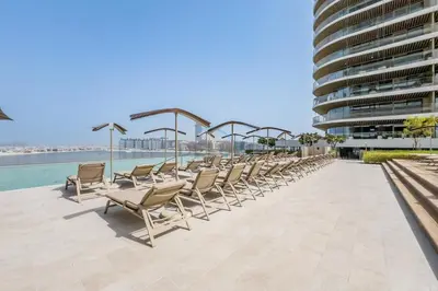 a row of chairs sitting on top of a building at Balcony with Majestic Sea and Palm View with Assistant Room, Private Beach Access, Minutes from Marina and Palm Jumeirah Destinations, Emaar Beachfront by Deluxe Holiday Homes in Dubai