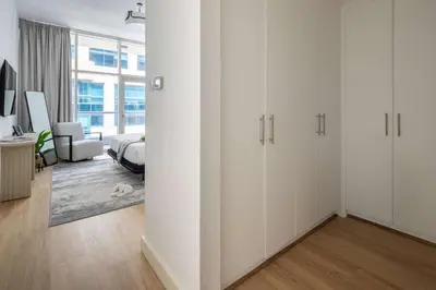 a white bedroom with white cabinets and a bed at Frank Porter - Bay Square 1 in Dubai