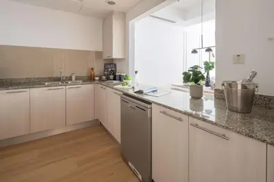 a kitchen with white cabinets and a large window at Frank Porter - Bay Square 1 in Dubai