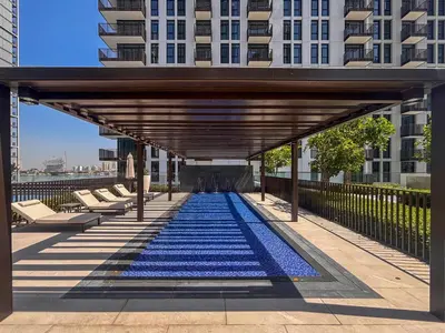 a large pool with blue tiles on the floor of a building at Frank Porter - Creek Crescent Tower in Dubai