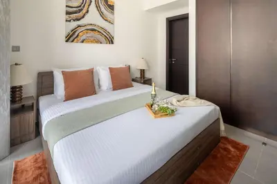 a bedroom with a large white bed with a tray on it at Frank Porter - Merano Tower in Dubai