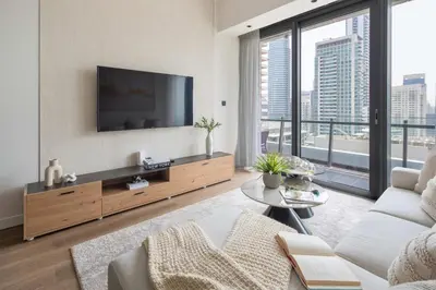 a living room with a tv and a large window at Frank Porter - Silverene Towers A in Dubai