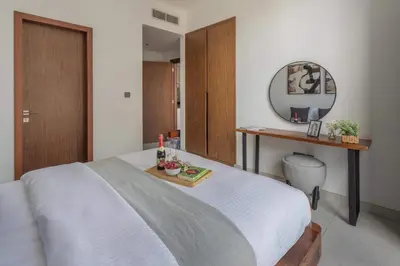 a bedroom with a bed with a table and a mirror at Frank Porter - No, 9 Dubai Marina in Dubai
