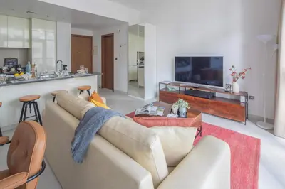 a living room with a couch and a television at Frank Porter - No, 9 Dubai Marina in Dubai