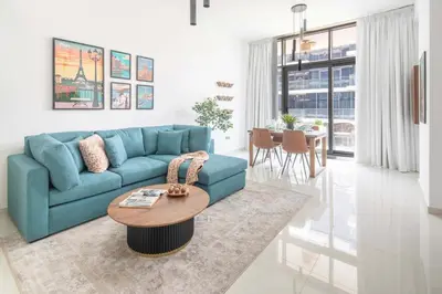 a living room with a blue couch and a table at Frank Porter - Loreto 3 in Dubai