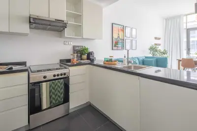 a kitchen with white cabinets and a stove top oven at Frank Porter - Loreto 3 in Dubai