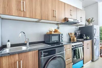 a kitchen with a washing machine and a microwave at Frank Porter - National Bonds Residence in Dubai