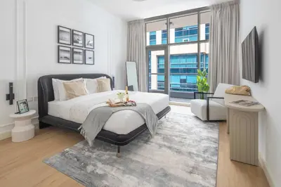 a bedroom with a bed and a living room at Frank Porter - Bay Square 1 in Dubai