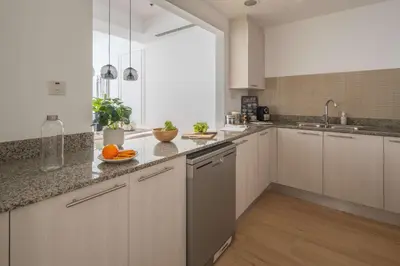 a kitchen with white cabinets and oranges on the counter at Frank Porter - Bay Square 1 in Dubai