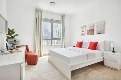 a white bedroom with a large white bed and a window at Frank Porter - Residences Tower 1 in Dubai