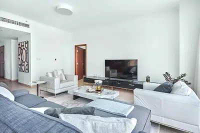 a living room with two couches and a tv at Frank Porter - Residences Tower 1 in Dubai