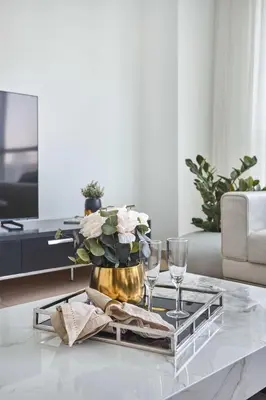 a living room with a coffee table with a gold vase at Frank Porter - Residences Tower 1 in Dubai