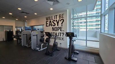 a gym with a sign that says will it be easy at Private 2BR Oasis with Jacuzzi, Massage Chair, PS5, Steps Away From Opera, Dubai Mall, Dubai Fountains in Dubai