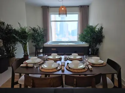 a dining room table with plates and dishes on it at Private 2BR Oasis with Jacuzzi, Massage Chair, PS5, Steps Away From Opera, Dubai Mall, Dubai Fountains in Dubai