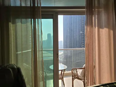 a room with a window with a view of a city at Private 2BR Oasis with Jacuzzi, Massage Chair, PS5, Steps Away From Opera, Dubai Mall, Dubai Fountains in Dubai