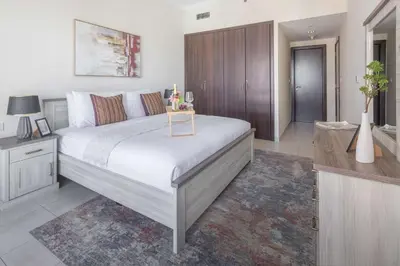 a bedroom with a large bed and a bathroom at Frank Porter - Churchill Residence Tower 2 in Dubai