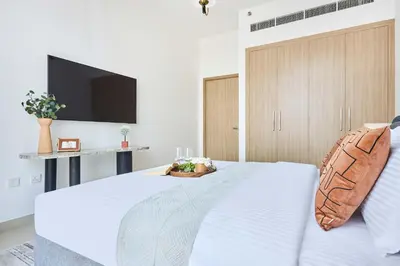 a bedroom with a white bed with a tv on the wall at Frank Porter - Azizi Park Avenue in Dubai