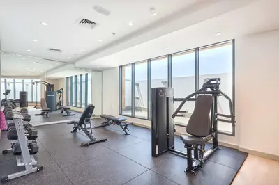 a gym with treadmills and exercise equipment and windows at Frank Porter - Azizi Park Avenue in Dubai