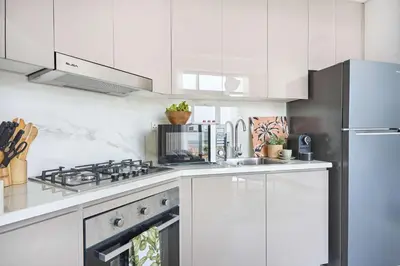 a white kitchen with a stove and a refrigerator at Frank Porter - Azizi Park Avenue in Dubai