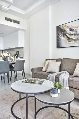 a living room with a couch and a table at Frank Porter - Samana Park Views in Dubai