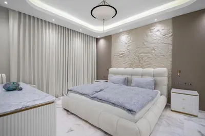 a bedroom with a large white bed and a stone wall at Fairmont Residence Modern 2bhk in Palm Jumeirah in Dubai