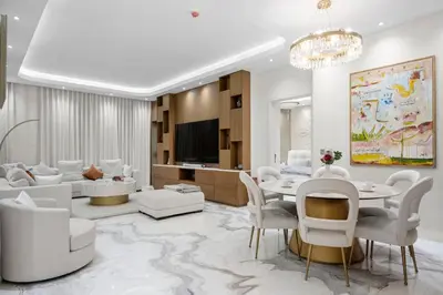 a living room with white furniture and a table and chairs at Fairmont Residence Modern 2bhk in Palm Jumeirah in Dubai
