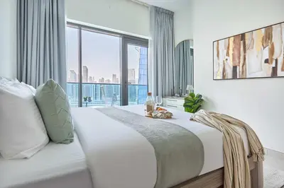 a bedroom with a white bed with a large window at Frank Porter - The Bay in Dubai
