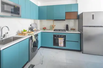 a blue kitchen with a sink and a refrigerator at Frank Porter - Opalz By Danube - Tower 2 in Dubai